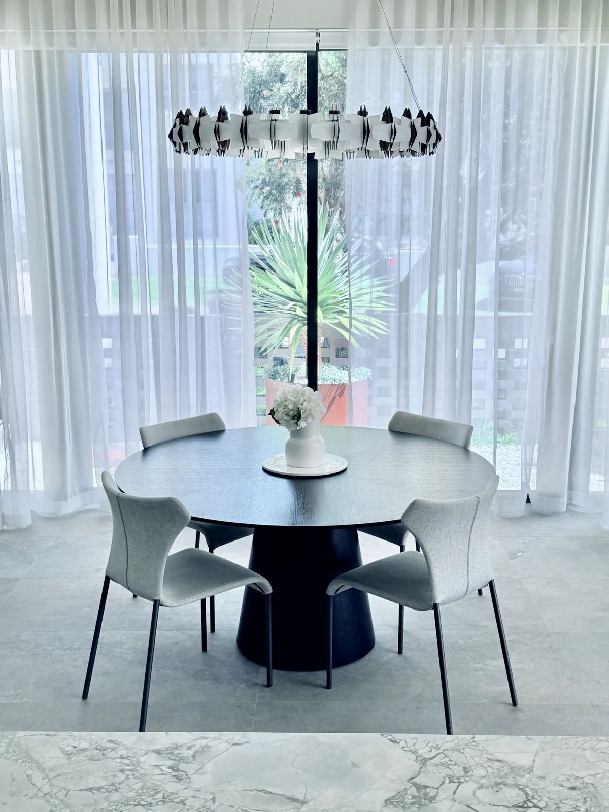 Dining room with full-height glazing and sheer curtains
